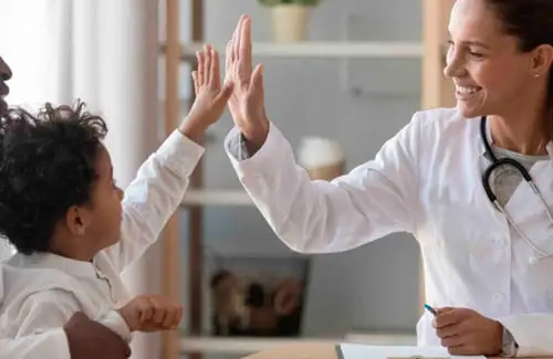 Children's Home Care ABA Therapy; Child giving high five to the doctor