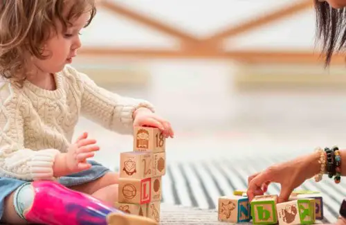 Children's Home Care ABA Therapy; Child playing with blocks on the floor