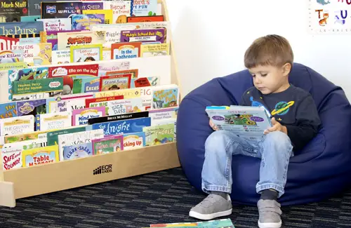 Blue Sprig; Child with autism sitting on bean bag reading a book