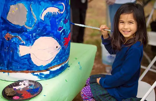 Bayou City Art Festival Memorial Park; child sitting and painting on barrel with sea creatures
