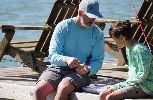 CCA-Texas-fishing-tournament-father-teaching-son-how-to-tie-fishing-lures; Coastal Conservation Association Summer Fishing Tournament Adults Children Kids Texas College Scholarships Events Prizes