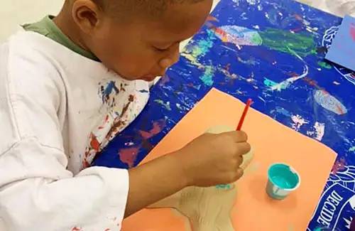 Student sculpting and painting at Kids' Clubhouse