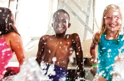 Swim lessons; Kids splashing and laughing in pool at Dad's Swim Club