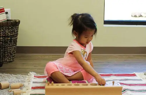 Child learning on rug at Elements Montessori; montessori preschool