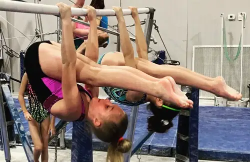 Two girls on the bars at Iron Cross Gymnastics