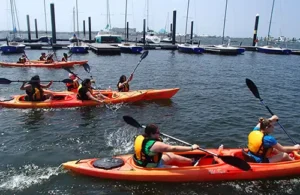 Aquatic summer camp; Group kayaking in harbor at Sea Star Base Galveston