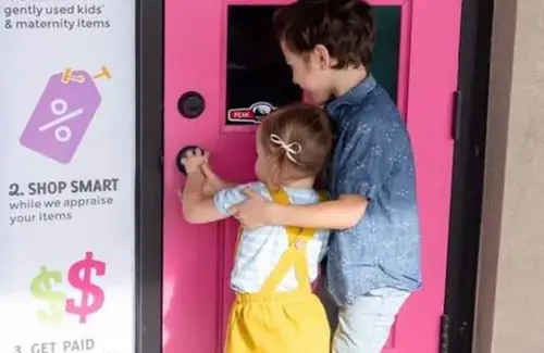Two kids opening pink door at Kid to Kid children's clothing upscale resale shop