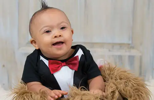 Cute baby boy with down syndrome smiling for picture