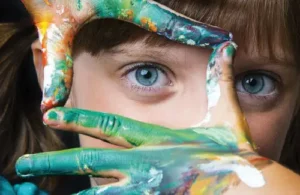 Summerfield Academy -child making a window out of painted fingers; preschool