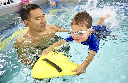 Child learning to swim at SwimLabs; swim school
