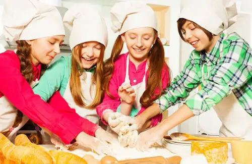 Cooking camp; Cooking competition with Group of friends as young chefs learning to make bread at urban CHEF; baking cooking summer camps