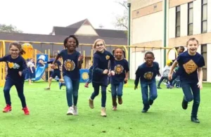 Kids running toward camera on playground field area at Westbury Christian School; religious schools