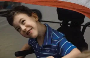 Young kid in wheelchair with disability having fun at Easter Seals Greater Houston The Caroline School; down syndrome and autism