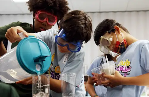 Group measuring out liquids for science experiment at Club SciKidz Houston.
