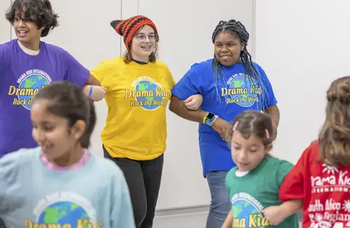 Group at Drama Kids holding arms during acting lessons.