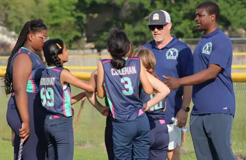 Coaches having a team talk with the softball players