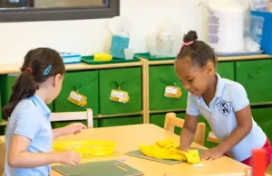 Silverline Montessori students sitting at a table completing a montessori activity.