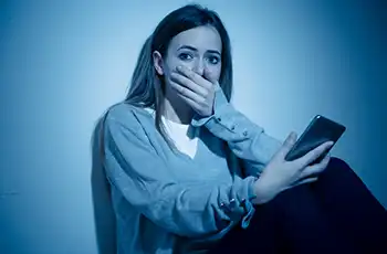 Negative Impacts Of AI And Social Media On Teen Friendships blog article image. Depressed teen sitting against wall; child development health wellness and safety.