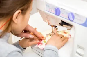 The Sewcial Box; One-of-a-kind sewing and quilting wonderland. Sewing student sitting at sewing machine being helped by instructor.