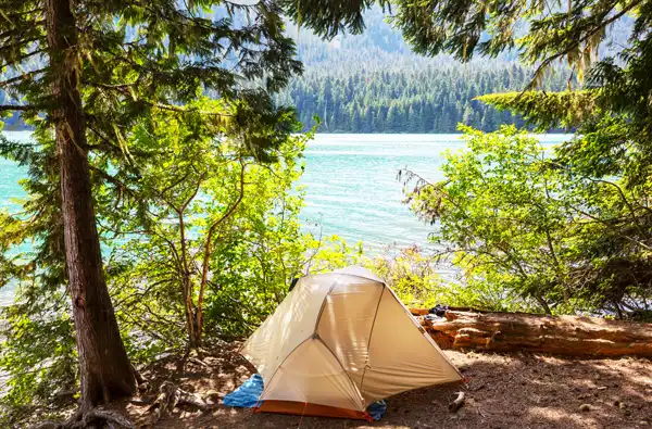 Spring Break 2026 Free Activities main image for the blog article; campsite with tent overlooking the lake and pine trees.