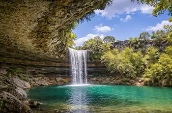 Natural Waterfall Adventures in Texas blog article main image showing an oasis of greenery and a waterfall.