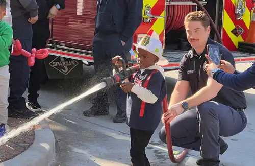 Kid spraying fire hose at the Houston Fire Museum.