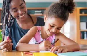 Read-A-Rific; mother and child sitting at a table in the house together using pencils and crayons. The best reading comprehension program