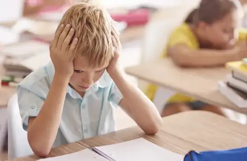 Read-A-Rific; struggling student sitting at his desk with his hands on his head.
