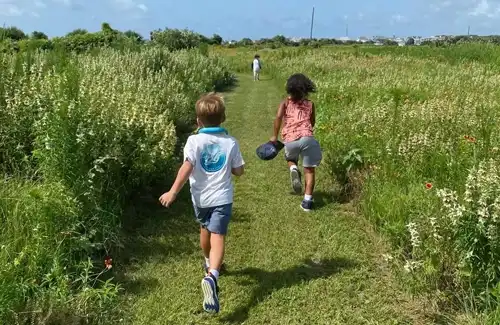 Kids at Artist Boat camp Where The Wild Things Grow running on a trail through the prairie. Artist Boat Galveston Activities and Camps!